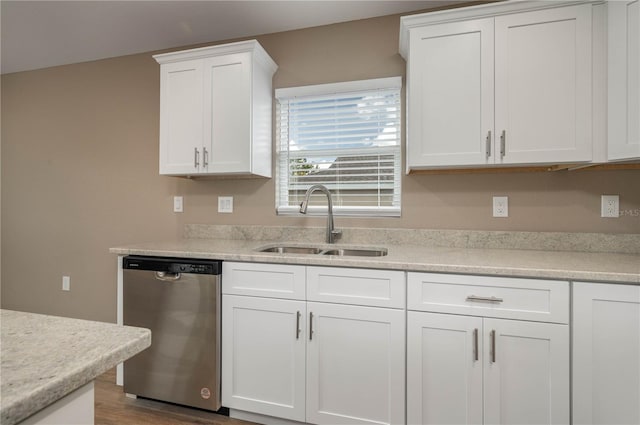 kitchen featuring dishwasher, sink, hardwood / wood-style floors, and white cabinets