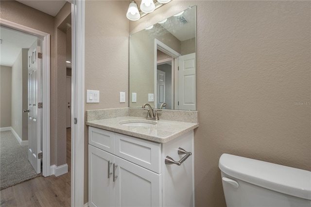 bathroom featuring hardwood / wood-style flooring, vanity, and toilet