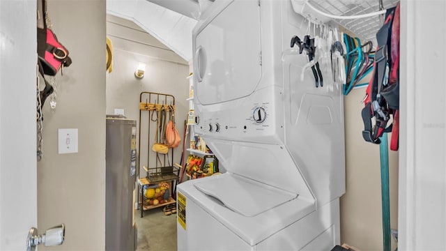 clothes washing area featuring stacked washer and dryer and electric water heater