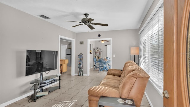 living room featuring light tile patterned flooring, ceiling fan, and plenty of natural light