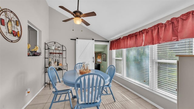 dining room with light tile patterned floors, vaulted ceiling, a barn door, and ceiling fan