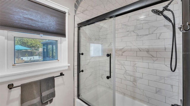 bathroom with bath / shower combo with glass door