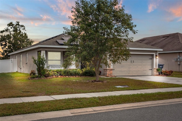 view of front facade with solar panels, a garage, and a lawn