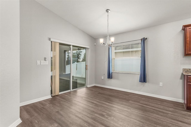 unfurnished dining area with dark hardwood / wood-style floors, vaulted ceiling, and a notable chandelier