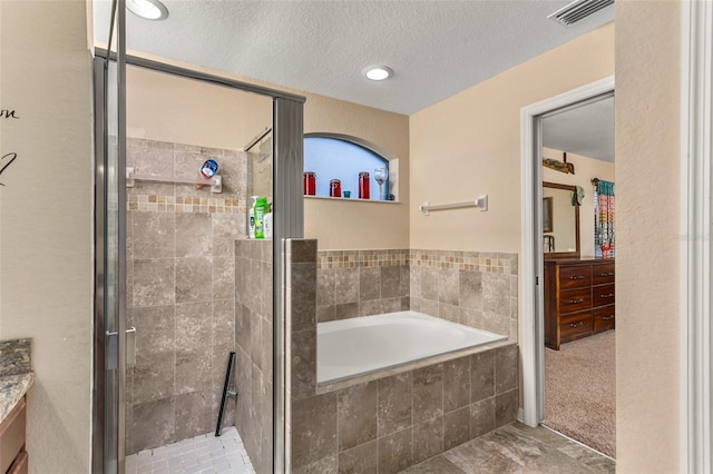 bathroom featuring separate shower and tub, vanity, and a textured ceiling