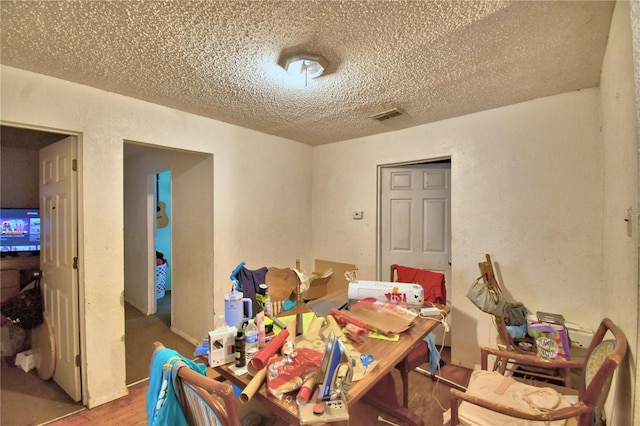 dining area with hardwood / wood-style floors and a textured ceiling