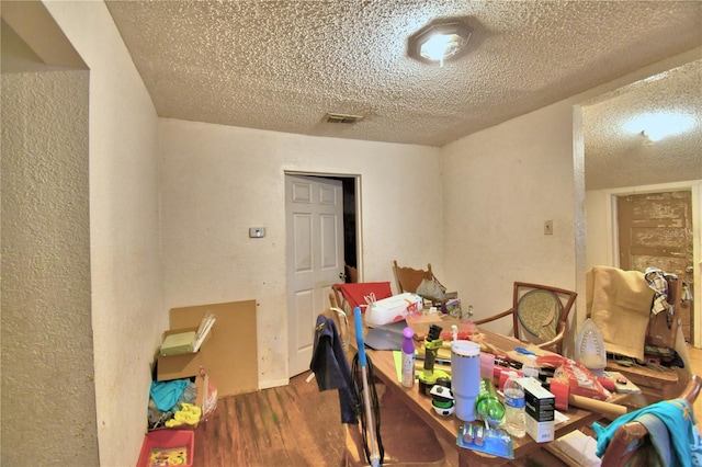 dining space featuring a textured ceiling and hardwood / wood-style flooring