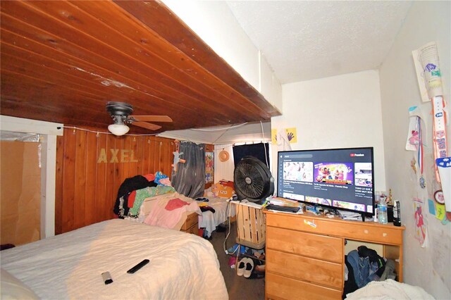 bedroom with ceiling fan and wooden walls