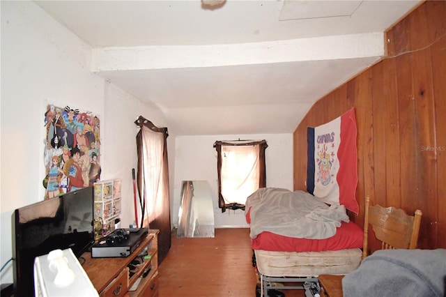 bedroom featuring hardwood / wood-style flooring, vaulted ceiling, and wood walls