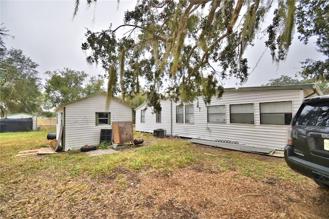 exterior space with central AC unit and a front lawn