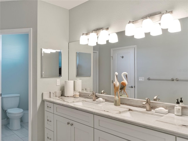 bathroom with tile patterned flooring, vanity, and toilet