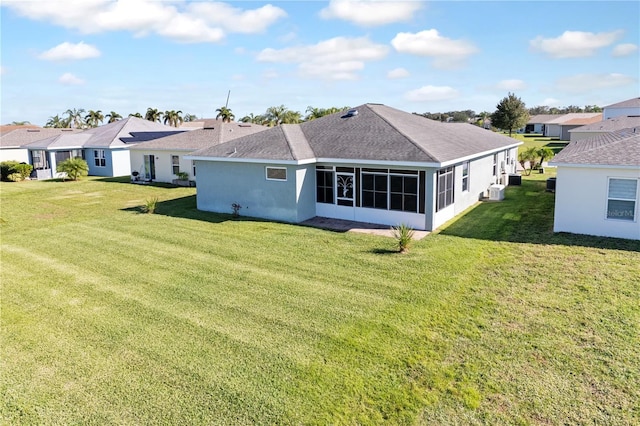 back of house with a sunroom and a lawn