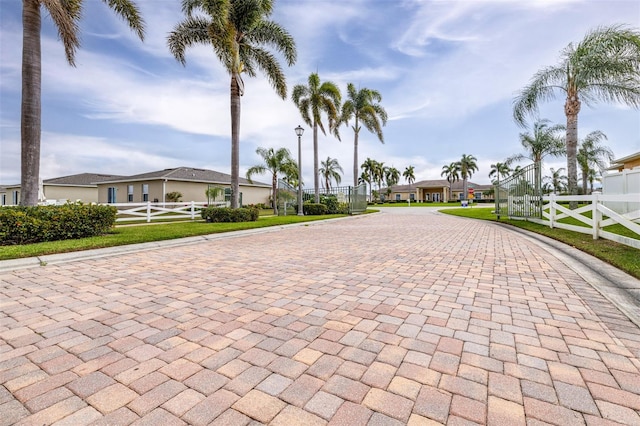 view of front of home featuring a fenced front yard, a residential view, a gate, and decorative driveway