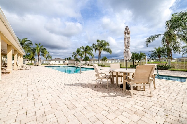 community pool featuring a patio area and fence