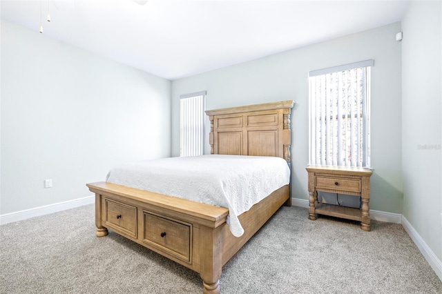 bedroom with light colored carpet and baseboards