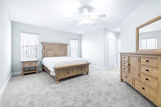 bedroom featuring light carpet, baseboards, and a ceiling fan