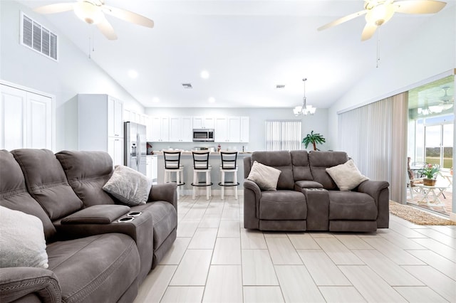 living area with high vaulted ceiling, a healthy amount of sunlight, visible vents, and ceiling fan with notable chandelier