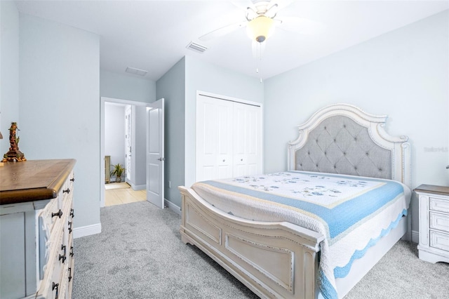 bedroom with visible vents, a ceiling fan, a closet, baseboards, and light colored carpet