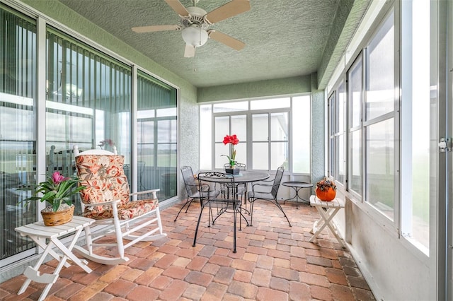 sunroom featuring a ceiling fan and a wealth of natural light