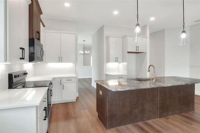 kitchen featuring white cabinets, sink, hanging light fixtures, and stainless steel electric range