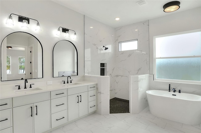 bathroom featuring ceiling fan, vanity, a healthy amount of sunlight, and independent shower and bath