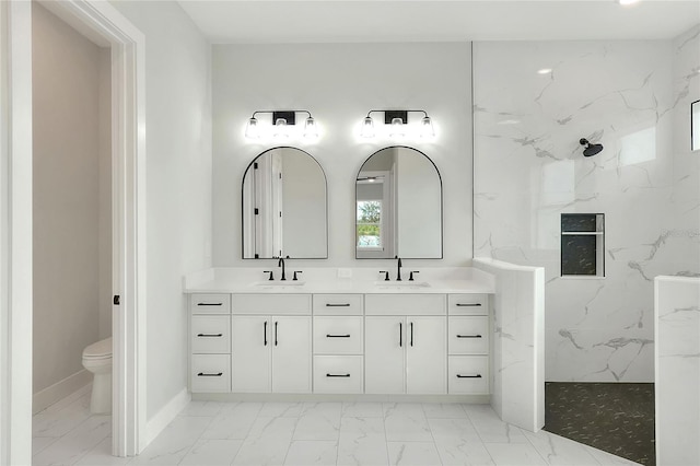 bathroom with vanity, toilet, and tiled shower