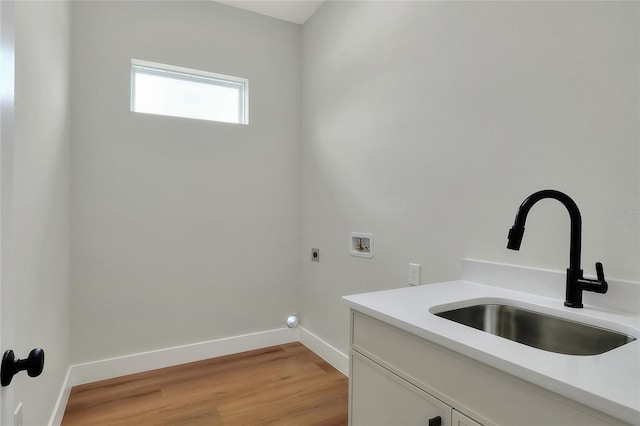 clothes washing area with sink, cabinets, washer hookup, electric dryer hookup, and light hardwood / wood-style floors