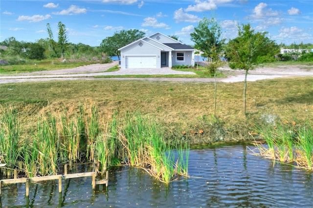 exterior space with a water view, a front yard, and a garage