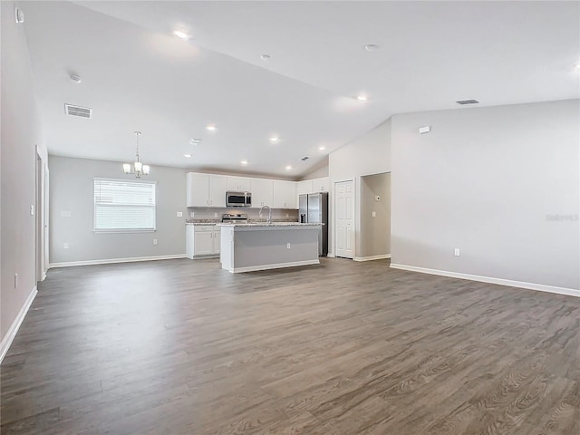 unfurnished living room with a notable chandelier, sink, lofted ceiling, and dark wood-type flooring