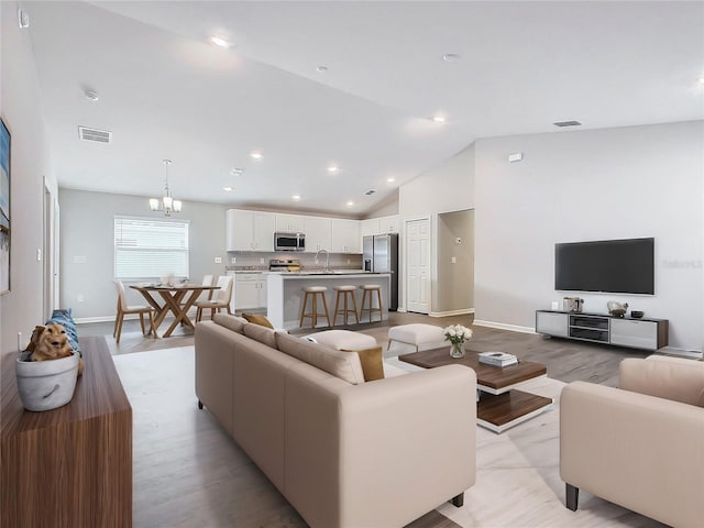 living area with recessed lighting, visible vents, baseboards, and an inviting chandelier