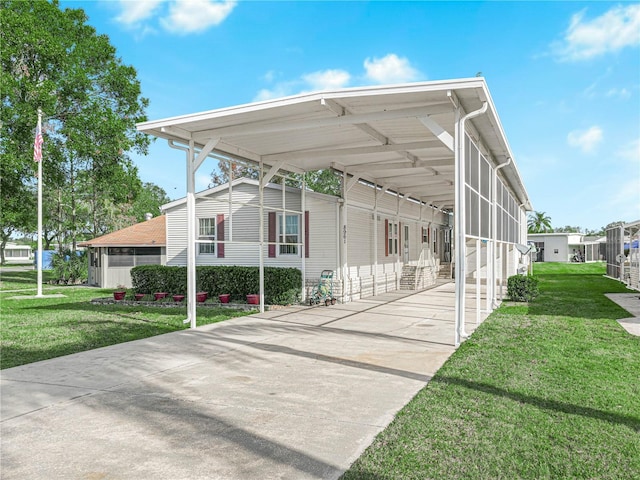 exterior space with a lawn, a sunroom, and a carport