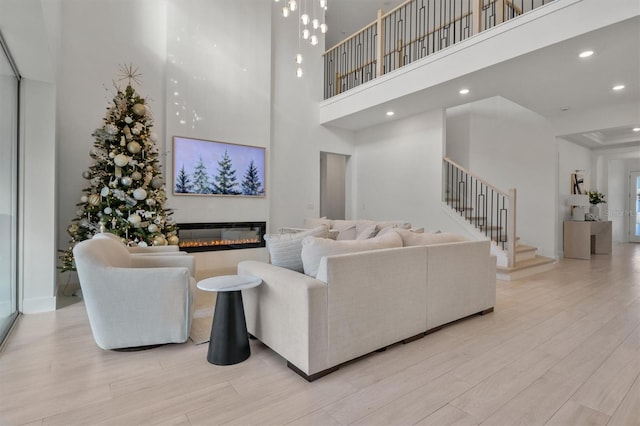 living room with a high ceiling and light wood-type flooring