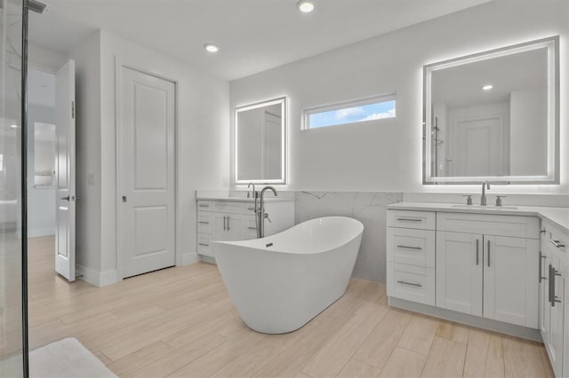 bathroom featuring a bathing tub, vanity, and tile walls