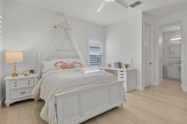 bedroom with ensuite bath, ceiling fan, and light hardwood / wood-style floors