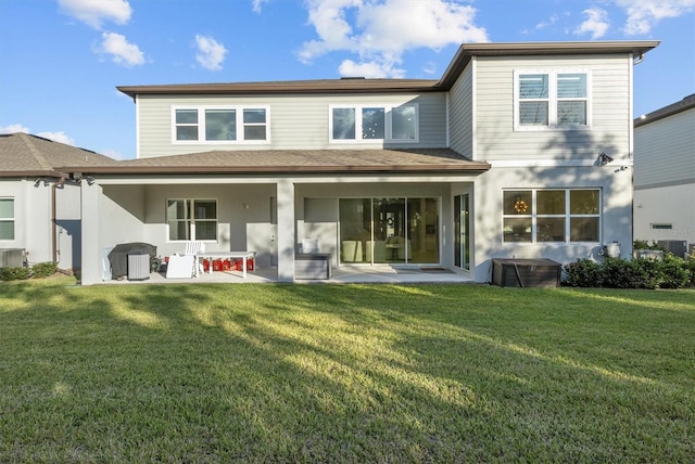 rear view of house featuring a yard, a patio, and central air condition unit