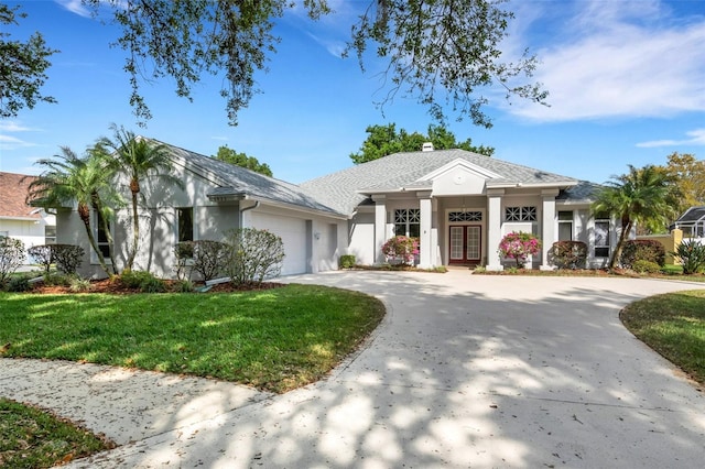 view of front of property with french doors, a front lawn, and a garage