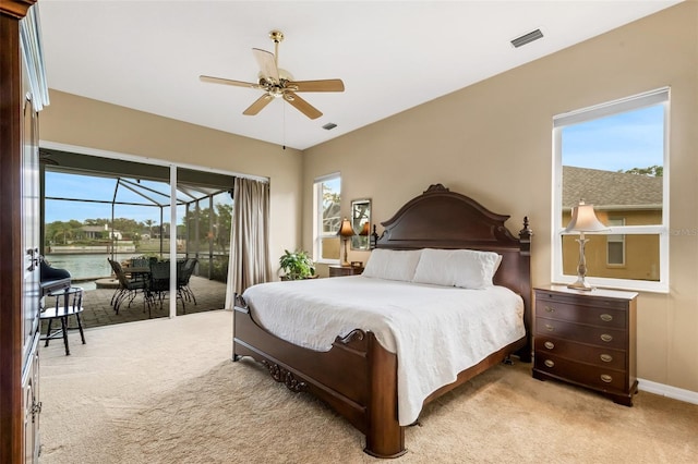 bedroom featuring access to outside, ceiling fan, a water view, and light carpet