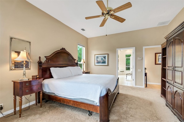 bedroom with connected bathroom, light colored carpet, and ceiling fan