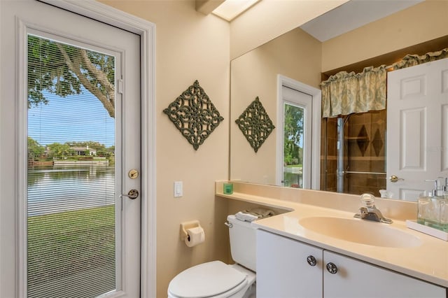 bathroom with vanity, a water view, a shower with shower curtain, and toilet