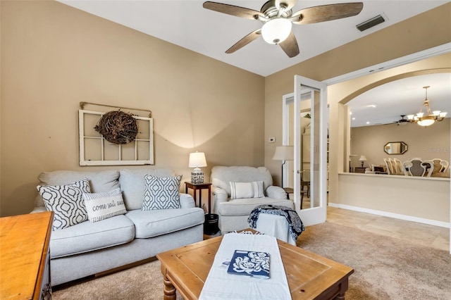 living room with light carpet and ceiling fan with notable chandelier