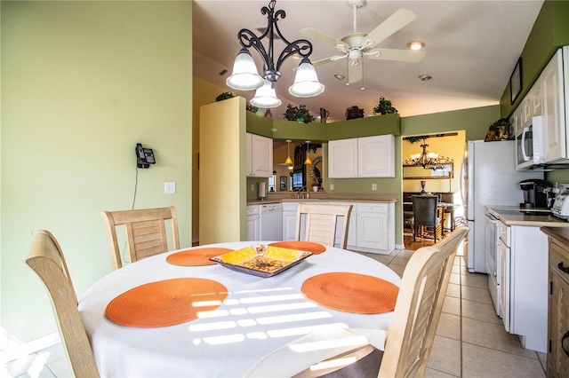 tiled dining room with ceiling fan with notable chandelier and vaulted ceiling