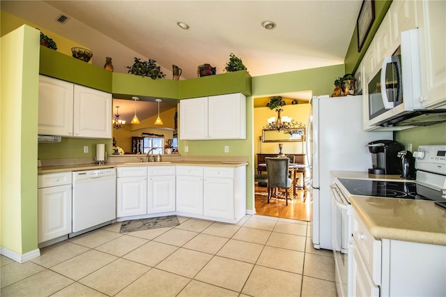 kitchen featuring white appliances, vaulted ceiling, white cabinetry, hanging light fixtures, and light tile patterned flooring