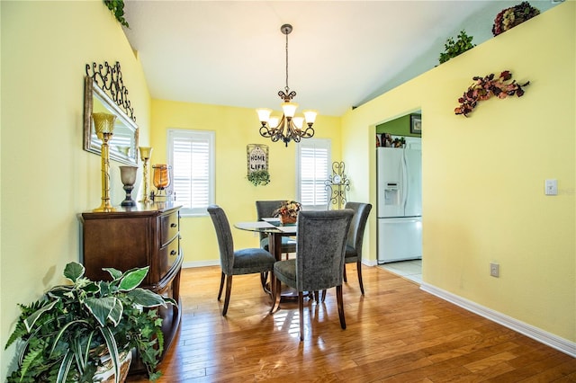 dining area with hardwood / wood-style flooring and a notable chandelier