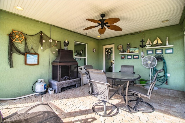 view of patio / terrace with ceiling fan and a fireplace