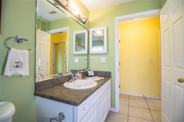 bathroom featuring tile patterned flooring, vanity, and toilet