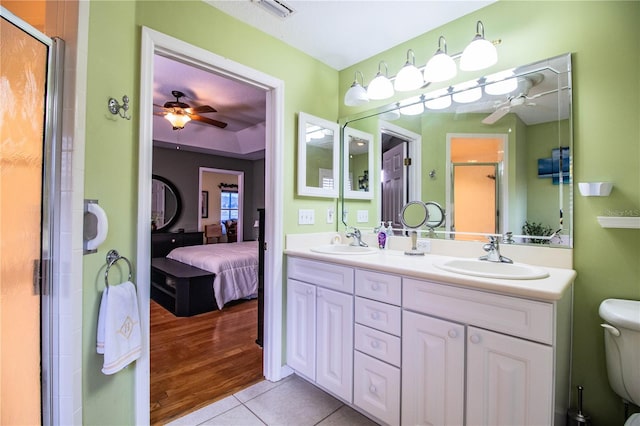 bathroom featuring ceiling fan, tile patterned floors, an enclosed shower, toilet, and vanity