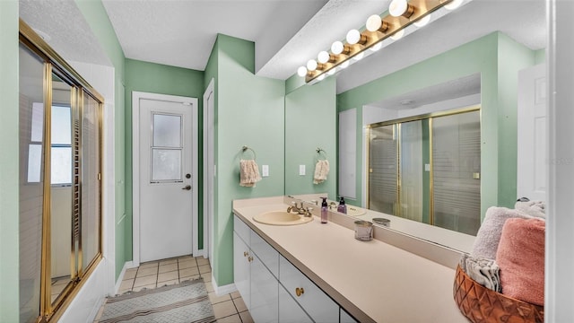 bathroom featuring tile patterned floors, vanity, and a textured ceiling