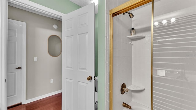 bathroom featuring shower / bathing tub combination and hardwood / wood-style flooring