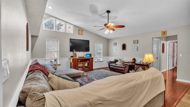 living room featuring ceiling fan, light hardwood / wood-style flooring, and lofted ceiling