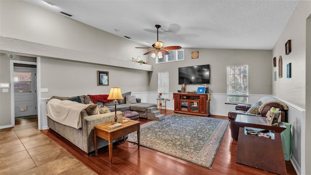 living room with hardwood / wood-style floors, a textured ceiling, ceiling fan, and lofted ceiling